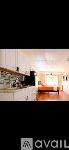 A kitchen with white cabinets and a black countertop.