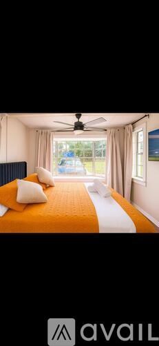 A bedroom with a bed and a ceiling fan.