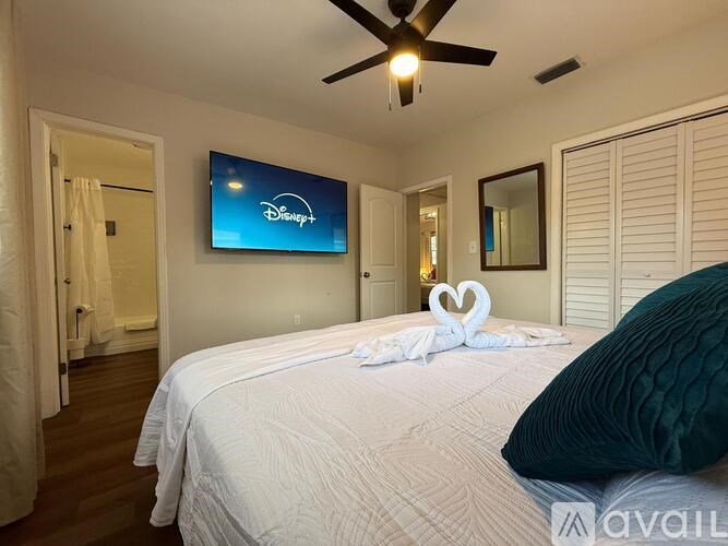 A bedroom with a Disney+ logo on the wall.