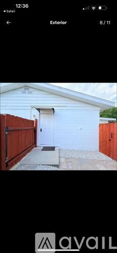 A white garage door is open to a driveway.