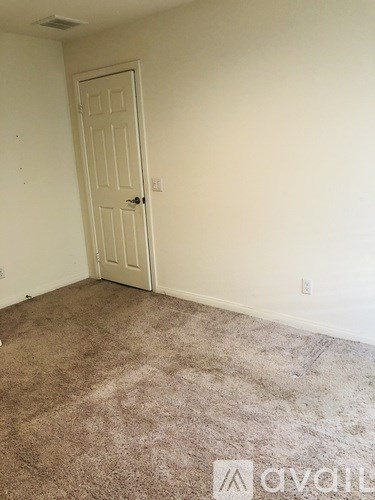 A room with a carpeted floor and a white door.