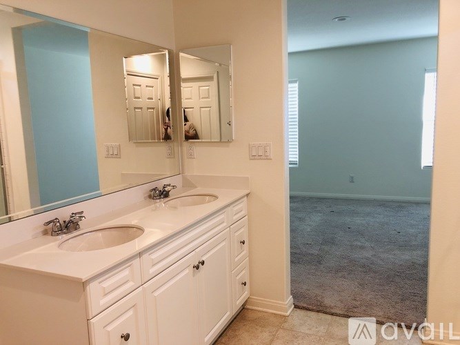 A bathroom with a white vanity and a large mirror.