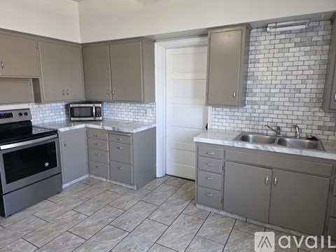 A kitchen with a tile backsplash and a sink.