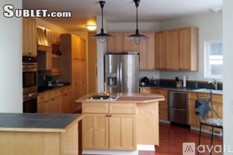 A kitchen with wooden cabinets and a stainless steel refrigerator.