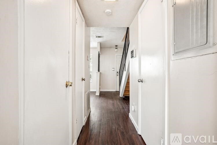 A long hallway with white walls and wood floors.