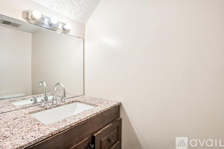 A bathroom with a sink and mirror.