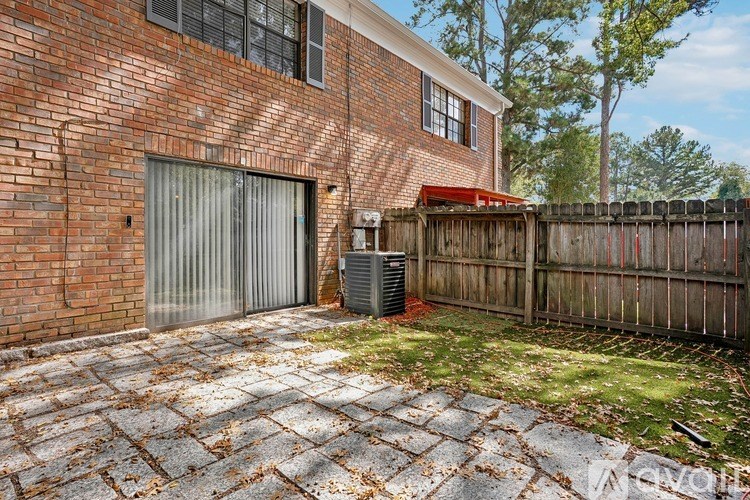 A red brick house with a wooden fence and a grey garage door.