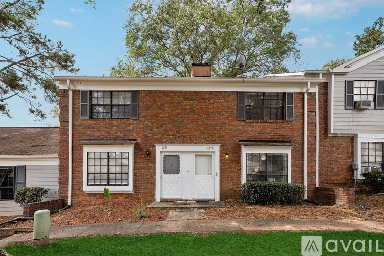 A house with a white door and windows is for sale.