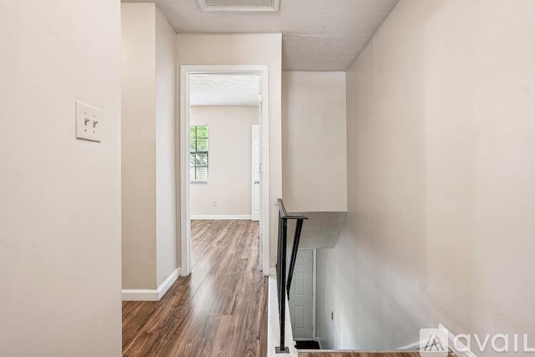 A room with a white door and a light switch on the wall.