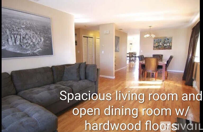 A spacious living room and open dining room with hardwood floors.
