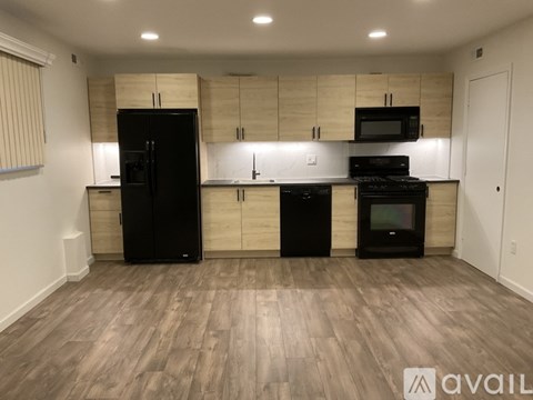 A kitchen with black appliances and wooden cabinets.