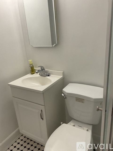 A white toilet with a sink and a mirror in a bathroom.