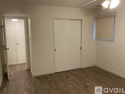 A room with a white door and a window with blinds.