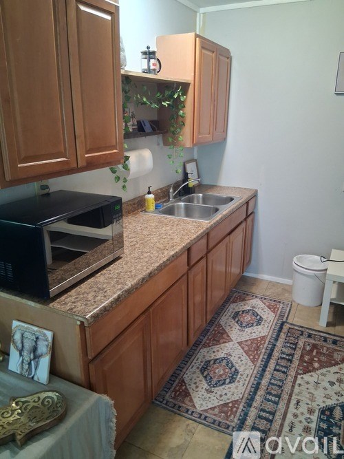A kitchen with brown cabinets and a granite countertop.