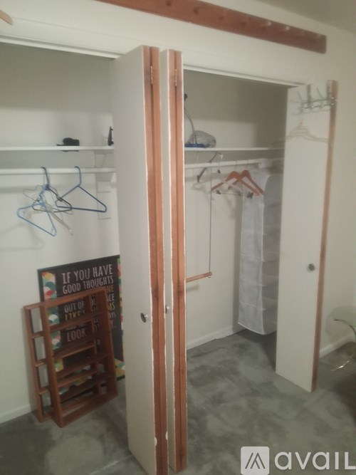 A room with a wooden door and a sign that says "If you have good thoughts, you will attract good things".