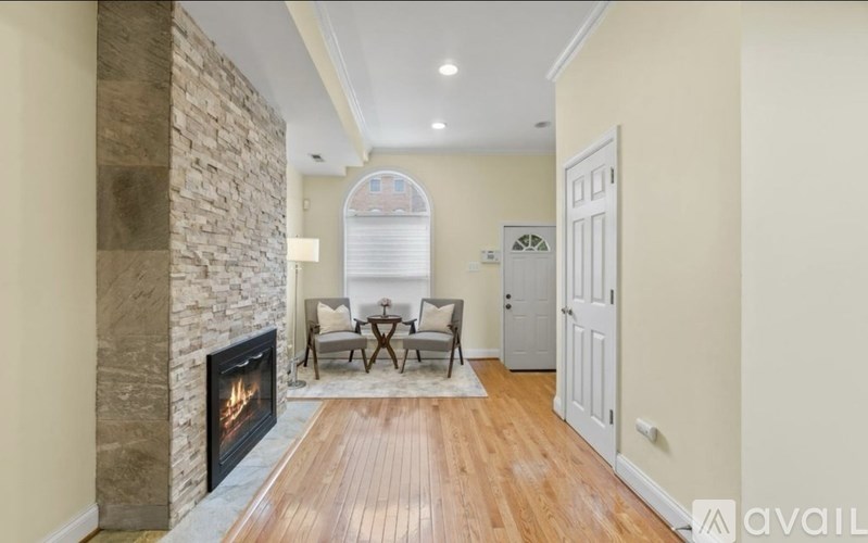 A living room with a stone fireplace and a wooden floor.