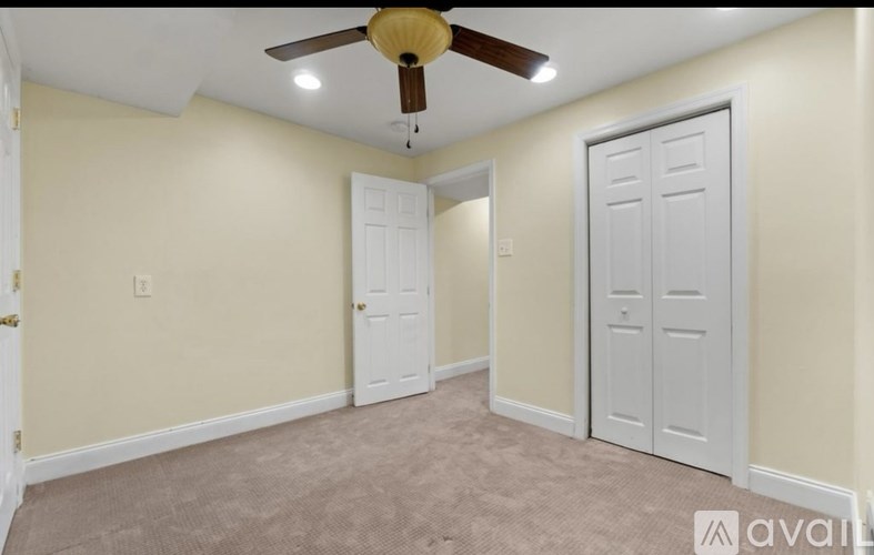 A room with a ceiling fan and two doors.