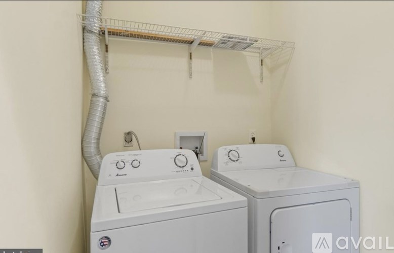 Two front loading washing machines in a small laundry room.