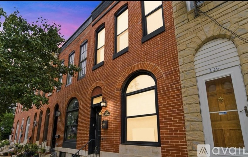 A red brick building with a white door and windows.