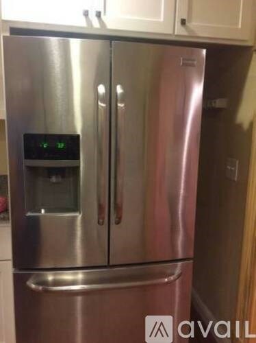A stainless steel refrigerator with a digital display on the door.