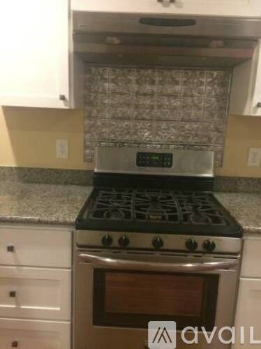 A stove with a digital display is in a kitchen.