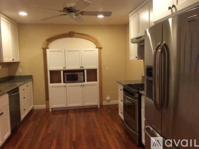 A kitchen with a refrigerator, oven, and microwave.