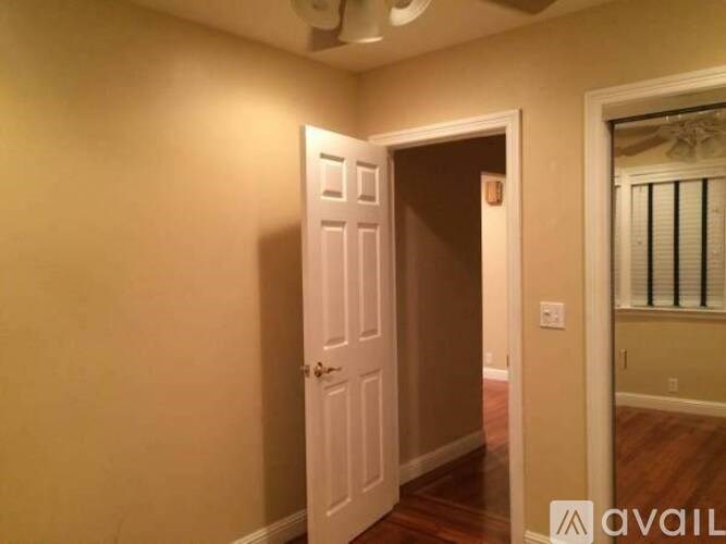 A room with a white door and a window with blinds.