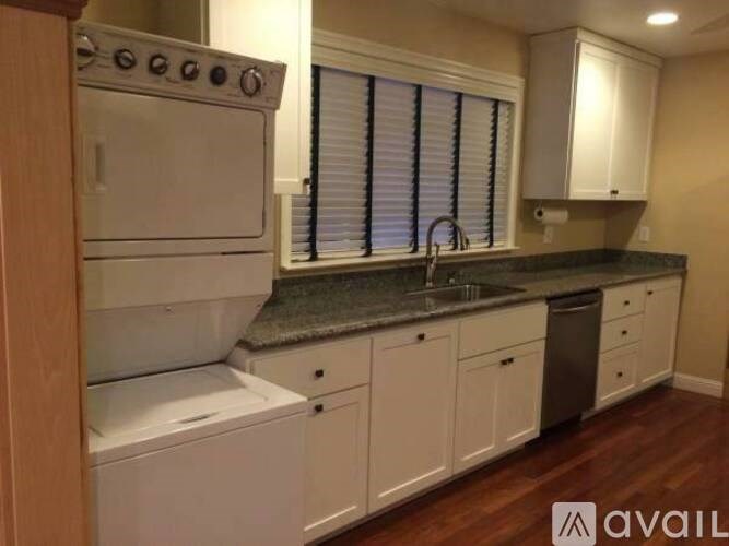 A kitchen with white appliances and cabinets.