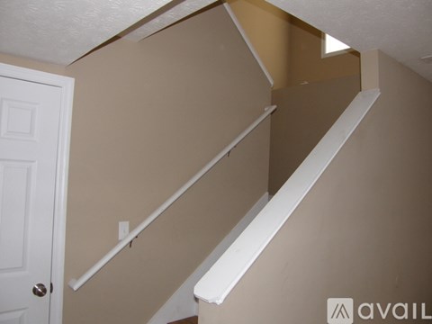 A white staircase with a white door on the left.
