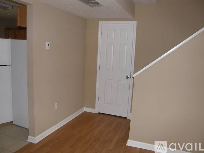 A room with a white door and a white fridge.