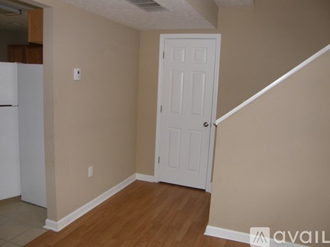 A room with a white door and a white fridge.
