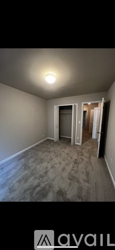 A room with a carpeted floor and a doorway leading to another room.
