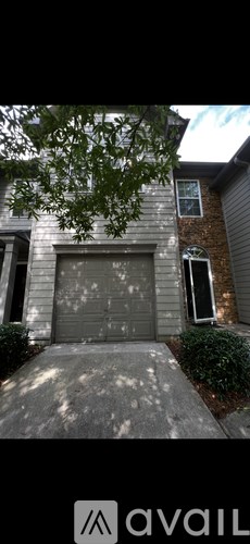 A house with a grey garage door and a brick chimney.