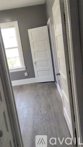 A white door is in a room with grey walls.