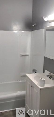 A bathroom with a white tub and sink.