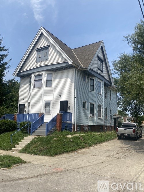 A two-story house with a blue fence in front.