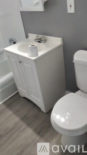 A white toilet and sink in a bathroom.