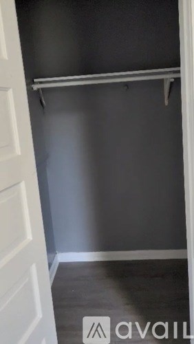 A white door is open to a room with a grey wall and a white shelf.