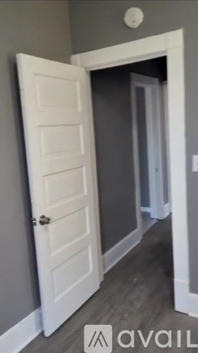 A white door is open to a hallway.