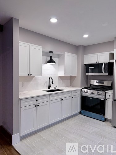 A modern kitchen with white cabinets and a blue oven.