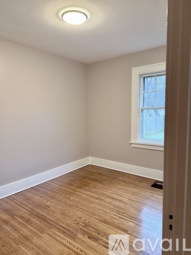 A room with wooden flooring and a window.