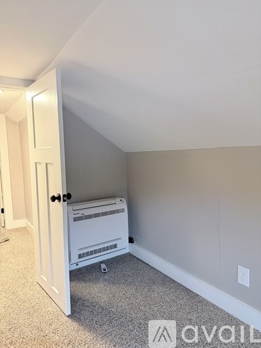 A white fridge in a room with a carpet floor.