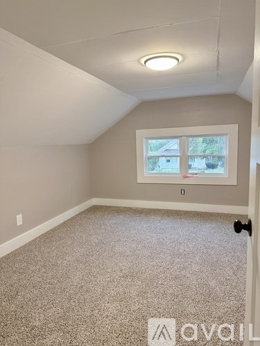 A room with a carpeted floor and a window.
