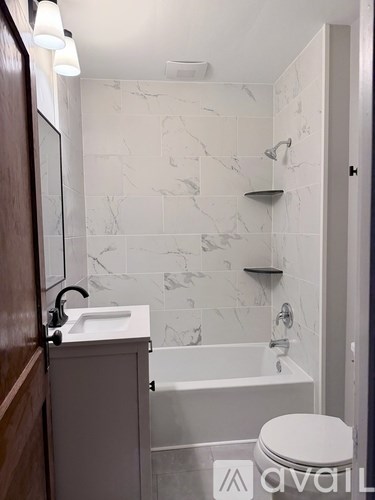 A bathroom with a marble wall and a white toilet.