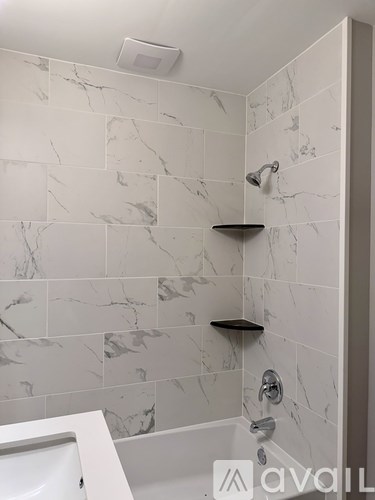 A white sink in a bathroom with marble tiles.