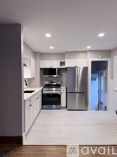 A modern kitchen with stainless steel appliances and white cabinetry.