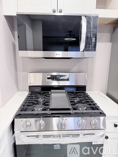 A modern kitchen with a stainless steel stove and white cabinets.