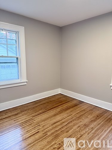 A room with wooden flooring and a window.