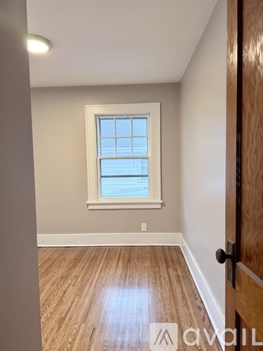 A room with a window and wooden flooring.