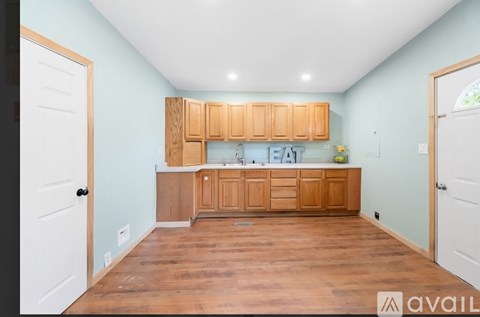 A kitchen with wooden cabinets and a white door.